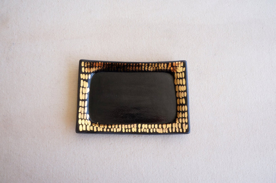 Rectangular ceramic tray in black and gold designed to hold jewelry and other small items