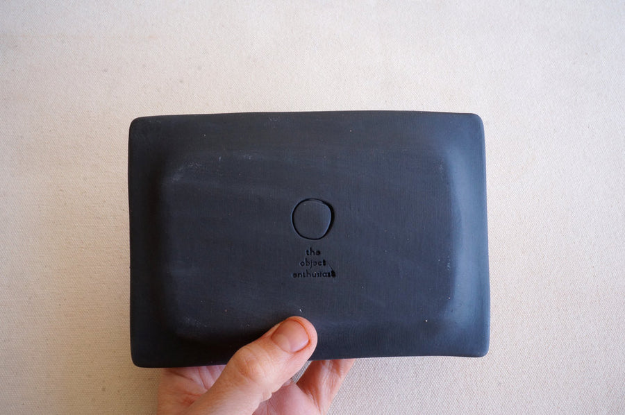 Showing the back of the handmade black ceramic jewelry tray designed by The Object Enthusiast